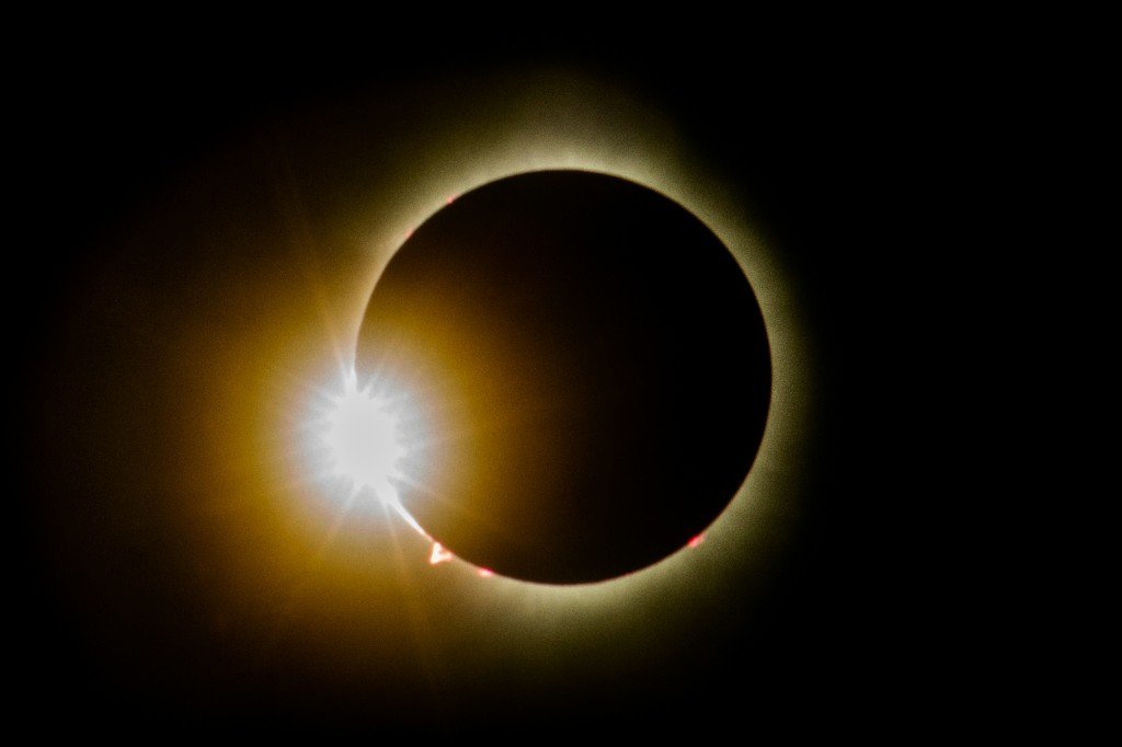Total solar eclipse showing the diamond ring effect — a brilliant point of sunlight on the lunar limb with the corona and Baily's beads visible.