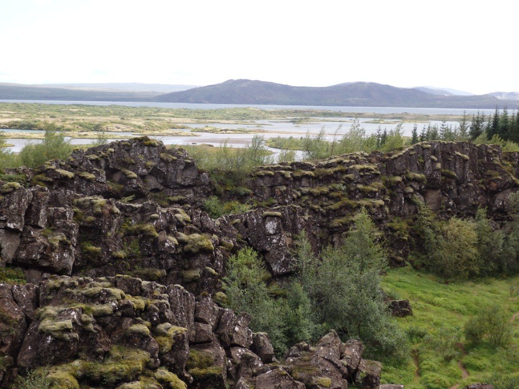 Moss-covered volcanic rock formations and a green valley in the Icelandic highlands.