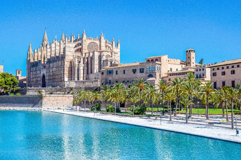 La Seu cathedral and the Royal Palace seen from the Parc de la Mar promenade and turquoise pool in Palma.